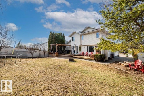 Expansive backyard featuring a large wooden deck, pergola, and raised garden beds - 86 Westpark Way, Fort Saskatchewan, AB - Outdoor With Deck Patio Veranda