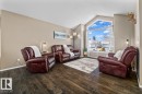 Vaulted living area featuring a large arched window with transom details, wood-finish flooring, and neutral wall tones - 86 Westpark Way, Fort Saskatchewan, AB  - Indoor Photo Showing Living Room 