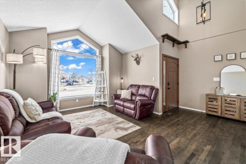 Spacious living area featuring a vaulted ceiling and an expansive arched window - 86 Westpark Way, Fort Saskatchewan, AB - Indoor Photo Showing Living Room