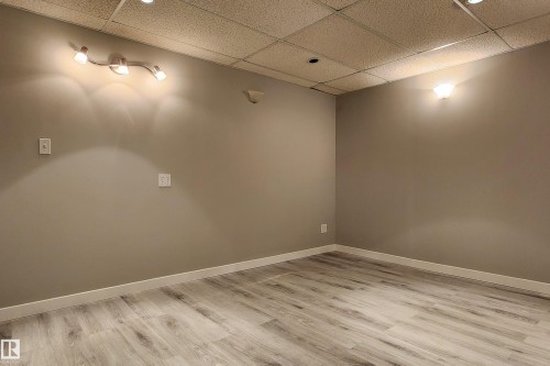Room featuring light wood-finish flooring, neutral wall tones, and white baseboards - 4911 106 Street, Edmonton, AB - Indoor Photo Showing Other Room