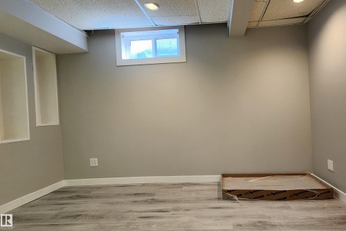 Finished lower level room featuring recessed lighting, a window, wood-finish flooring, and built-in wall niches - 4911 106 Street, Edmonton, AB - Indoor