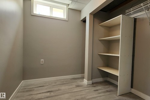 Room featuring wood-finish flooring, neutral wall paint, and a white trim baseboard - 4911 106 Street, Edmonton, AB - Indoor