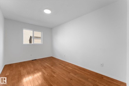 Spacious room featuring wood-finish flooring, white walls, and a recessed ceiling light - 326 Silver Berry Road, Edmonton, AB - Indoor Photo Showing Other Room