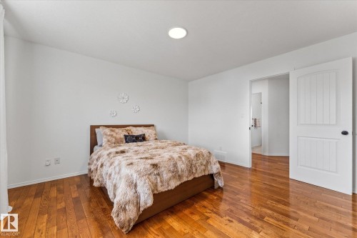 Hardwood flooring throughout, white walls, recessed ceiling light, and a white paneled door - 326 Silver Berry Road, Edmonton, AB - Indoor Photo Showing Bedroom