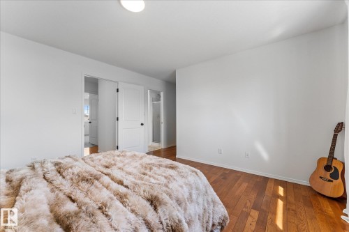 Neutral tone walls with wood-finish flooring - 326 Silver Berry Road, Edmonton, AB - Indoor Photo Showing Bedroom