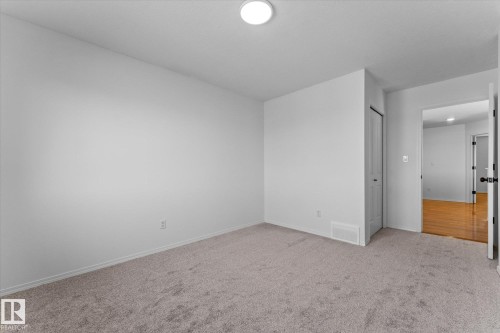 Spacious room featuring neutral carpeting, light-colored wall paint, white trim, and a white ceiling with a flush-mount light fixture - 326 Silver Berry Road, Edmonton, AB - Indoor Photo Showing Other Room