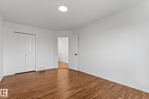 Spacious room featuring wood-finish flooring, white walls, and a recessed ceiling light - 326 Silver Berry Road, Edmonton, AB - Indoor Photo Showing Other Room