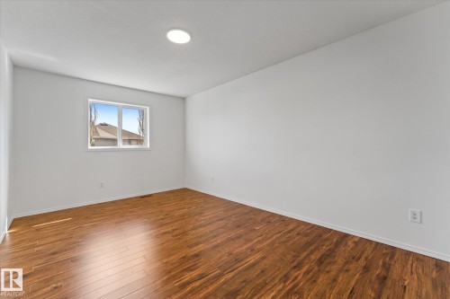 Expansive room featuring wood-finish flooring, crisp white walls, and a recessed ceiling light - 326 Silver Berry Road, Edmonton, AB - Indoor Photo Showing Other Room
