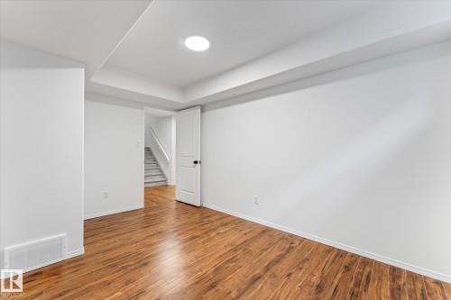Spacious room featuring wood-finish flooring, white walls, and recessed lighting - 326 Silver Berry Road, Edmonton, AB - Indoor Photo Showing Other Room