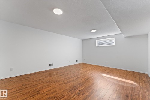 Spacious room featuring wood-finish flooring, recessed lighting, a white window with horizontal blinds, and a white ceiling - 326 Silver Berry Road, Edmonton, AB - Indoor Photo Showing Other Room