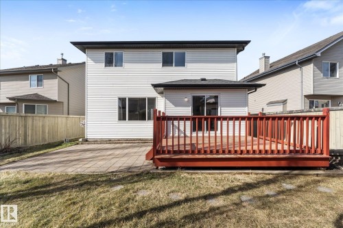 Expansive backyard featuring a wood deck with red railing, sliding glass door access, a paver patio, and a privacy fence - 326 Silver Berry Road, Edmonton, AB - Outdoor With Deck Patio Veranda With Exterior