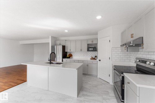 Modern kitchen featuring a central island with an undermount sink and matte black faucet, light grey cabinetry, white subway tile backsplash, stainless steel appliances, and recessed lighting - 326 Silver Berry Road, Edmonton, AB - Indoor Photo Showing Kitchen With Stainless Steel Kitchen With Upgraded Kitchen