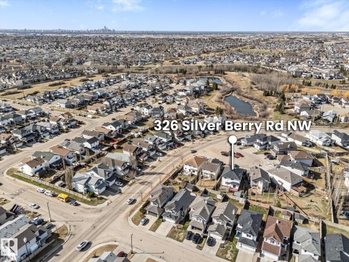 Residential neighborhood featuring varied housing styles, mature trees, and a distant cityscape - 326 Silver Berry Road, Edmonton, AB - Outdoor With View