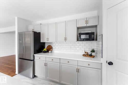 Modern kitchen featuring light gray cabinetry, a white countertop, and a classic white subway tile backsplash - 326 Silver Berry Road, Edmonton, AB - Indoor Photo Showing Kitchen