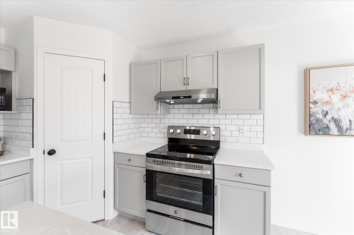 Kitchen area featuring light gray cabinetry, stainless steel range and hood, white subway tile backsplash, and light-toned countertops - 326 Silver Berry Road, Edmonton, AB - Indoor Photo Showing Kitchen