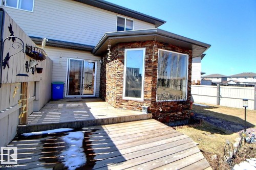 Exterior features include a multi-level wooden deck, stone-accented sunroom with multiple windows, and light-toned siding - 2927 30 Street, Edmonton, AB - Outdoor With Deck Patio Veranda