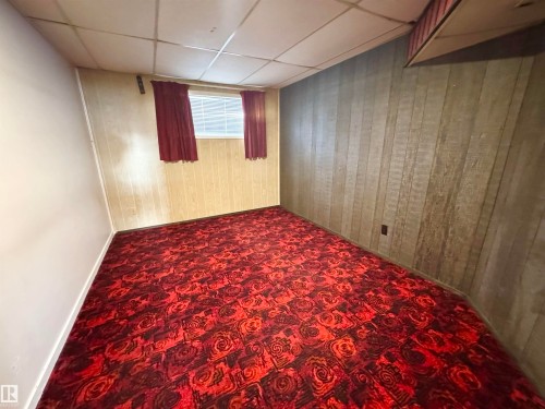 Room featuring red patterned carpeting, paneled walls, and a window with blinds - 8507 35 Avenue, Edmonton, AB - Indoor