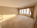 This spacious room features a curved bay window, offering natural light and views of the exterior - 8507 35 Avenue, Edmonton, AB  - Indoor Photo Showing Other Room 