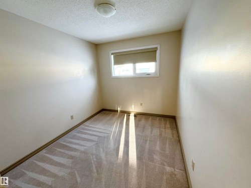 This room features light-colored carpet, a window with a roller blind, and a ceiling-mounted light fixture - 8507 35 Avenue, Edmonton, AB - Indoor Photo Showing Other Room