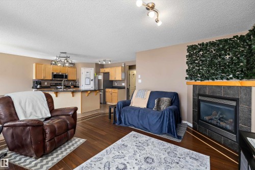 Living area featuring a fireplace with a stone surround and wood mantel - 992 Regency Drive, Sherwood Park, AB - Indoor Photo Showing Living Room With Fireplace
