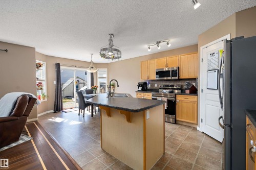 Open-concept kitchen featuring light wood cabinetry, stainless steel appliances, and a central island with a sink - 992 Regency Drive, Sherwood Park, AB - Indoor Photo Showing Kitchen With Double Sink