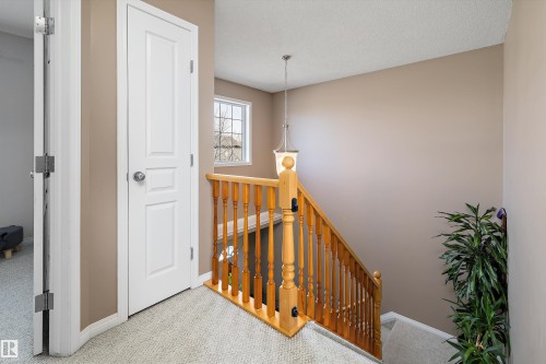 Carpeted staircase with natural wood railing and balusters - 992 Regency Drive, Sherwood Park, AB - Indoor Photo Showing Other Room