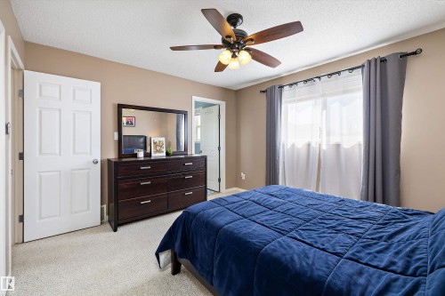 Bedroom featuring a ceiling fan with integrated lighting, a large window, and light-toned carpeting - 992 Regency Drive, Sherwood Park, AB - Indoor Photo Showing Bedroom