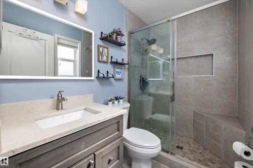 Modern bathroom featuring a glass-enclosed shower with a built-in bench and recessed niche - 992 Regency Drive, Sherwood Park, AB - Indoor Photo Showing Bathroom