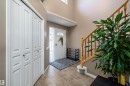 Foyer featuring vaulted ceilings, ceramic tile flooring, a staircase with wood banister, and bi-fold closet doors - 992 Regency Drive, Sherwood Park, AB  - Indoor Photo Showing Other Room 