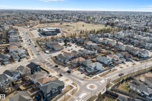 Aerial perspective of a residential community featuring diverse housing styles, paved roadways, and a central traffic circle - 992 Regency Drive, Sherwood Park, AB - Outdoor With View