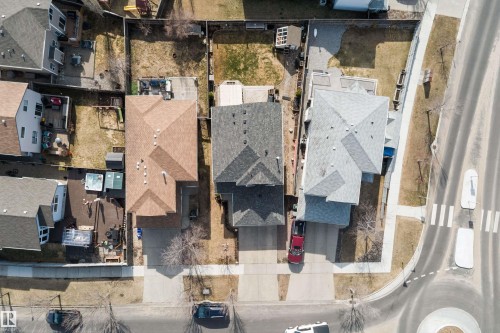 Residential property featuring a light brown shingle roof, paved driveway, and established front yard landscaping - 992 Regency Drive, Sherwood Park, AB - Outdoor
