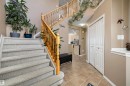 Foyer featuring a two-story staircase with light wood banisters, carpeted stairs, and neutral wall tones - 992 Regency Drive, Sherwood Park, AB  - Indoor Photo Showing Other Room 