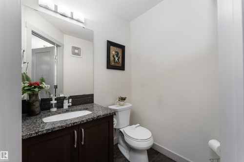 Bathroom featuring a dark wood-finish vanity with a granite countertop and an undermount sink - 15 5203 149 Avenue, Edmonton, AB - Indoor Photo Showing Bathroom