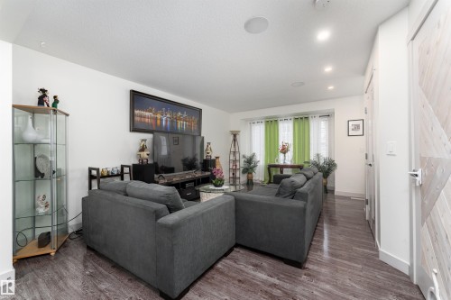 Spacious living area featuring wood-finish flooring, recessed lighting, and built-in ceiling speakers - 15 5203 149 Avenue, Edmonton, AB - Indoor Photo Showing Living Room