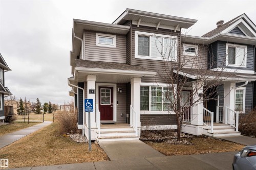 Contemporary townhome exterior featuring multi-toned siding, white trim, and a prominent dark red entry door - 15 5203 149 Avenue, Edmonton, AB - Outdoor With Facade