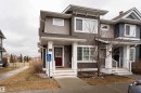 Contemporary townhome exterior featuring multi-toned siding, white trim, and a prominent dark red entry door - 15 5203 149 Avenue, Edmonton, AB  - Outdoor With Facade 
