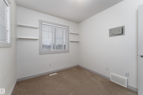 Carpeted room with a large window featuring horizontal blinds - 15 5203 149 Avenue, Edmonton, AB - Indoor Photo Showing Other Room