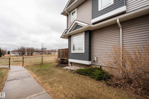 Two-story exterior featuring multi-toned siding, a bay window, and a wooden deck - 15 5203 149 Avenue, Edmonton, AB - Outdoor