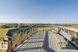 Expansive observation deck with natural wood decking and black metal railings - 