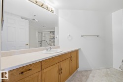Bathroom vanity with wood cabinetry, light countertop, and an integrated sink - 