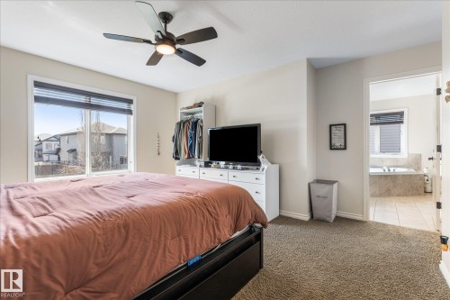 Carpeted room with a wide window and ceiling fan - 41 Heron Crescent, Spruce Grove, AB - Indoor Photo Showing Bedroom