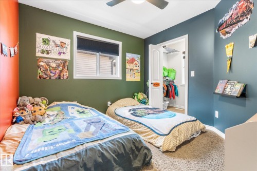 Spacious room featuring carpeting, a white trim window with roller shade, and a ceiling fan - 41 Heron Crescent, Spruce Grove, AB - Indoor Photo Showing Bedroom