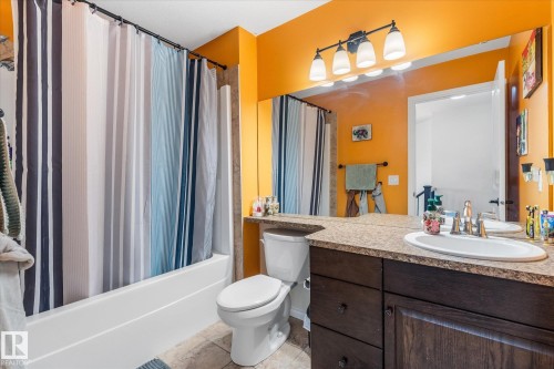 Bathroom featuring a dark wood-finish vanity with an integrated sink, a large wall-mounted mirror, and a five-light fixture - 41 Heron Crescent, Spruce Grove, AB - Indoor Photo Showing Bathroom