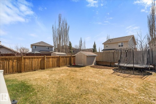 Expansive backyard featuring a wood privacy fence, a storage shed, and a raised garden bed - 41 Heron Crescent, Spruce Grove, AB - Outdoor