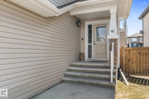 Front entry featuring a light-colored door with decorative glass, flanked by a sidelight - 41 Heron Crescent, Spruce Grove, AB - Outdoor With Exterior