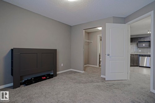 Carpeted room with neutral gray walls and white trim - 201 1520 Hammond Gate Gate, Edmonton, AB - Indoor Photo Showing Other Room
