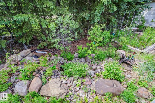 Landscaped garden bed featuring a variety of plantings, large natural boulders, and a rock-lined border - 400 60501 Range Road 120, Rural St. Paul County, AB - Outdoor