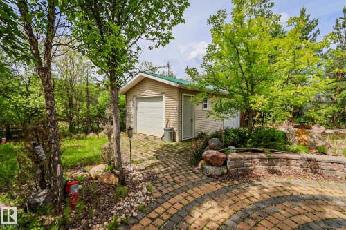 Detached garage featuring beige siding, green metal roofing, and a white garage door - 400 60501 Range Road 120, Rural St. Paul County, AB - Outdoor
