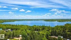 Expansive lake surrounded by dense, mature greenery - 
