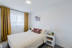 Bedroom with light gray carpeting, a window featuring sheer and opaque privacy curtains, and a flush-mount ceiling light fixture - 
